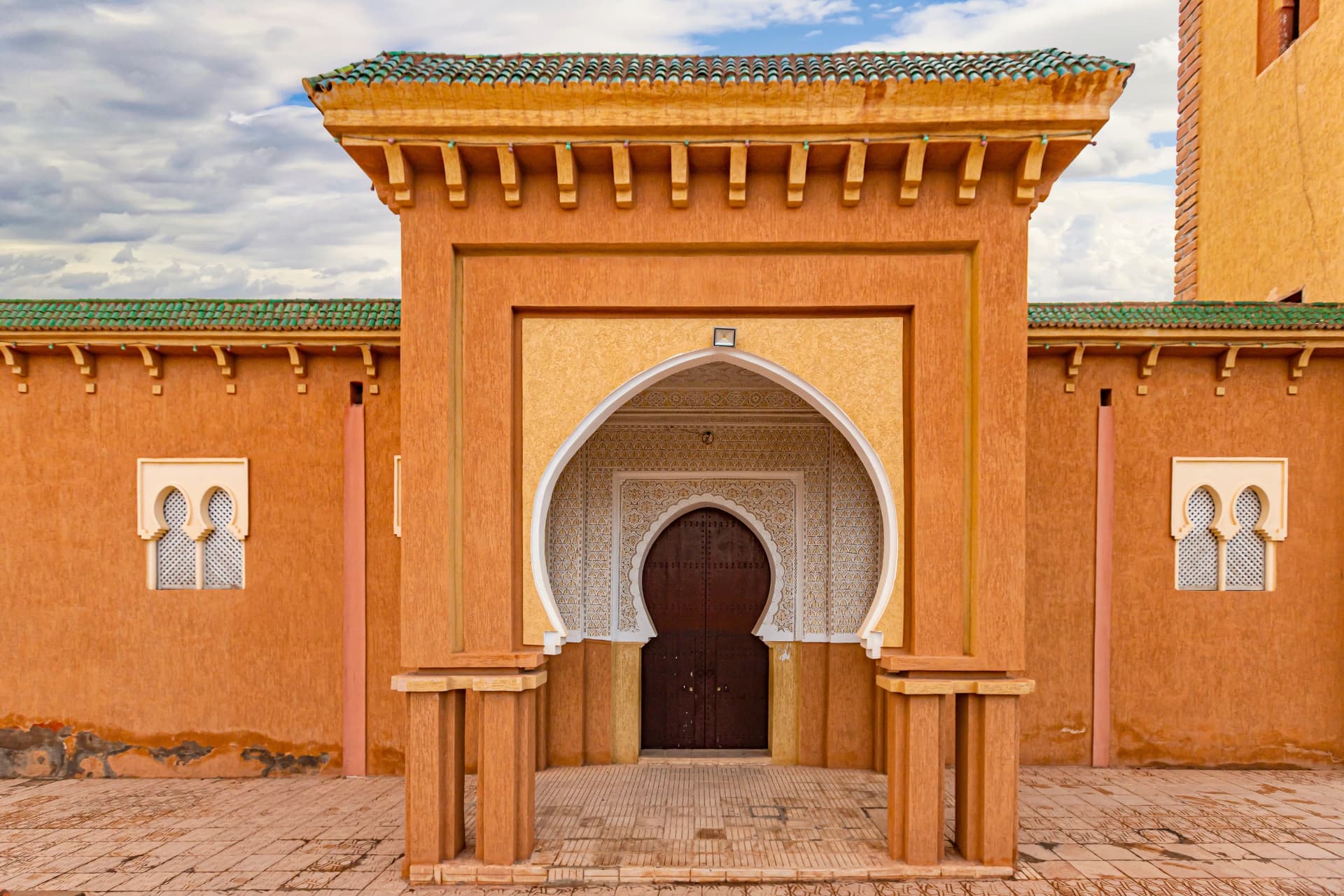 A carved horseshoe arch and doorway in terracotta Moroccan architecture
