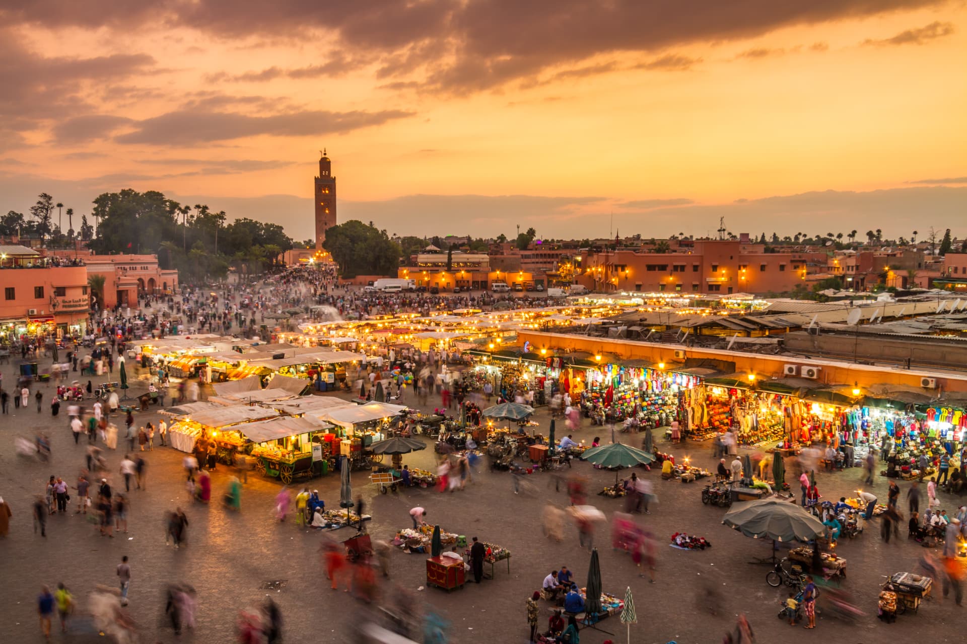 Marrakech's Jemaa el-Fnaa square at sunset, with the Koutoubia Mosque minaret rising above
